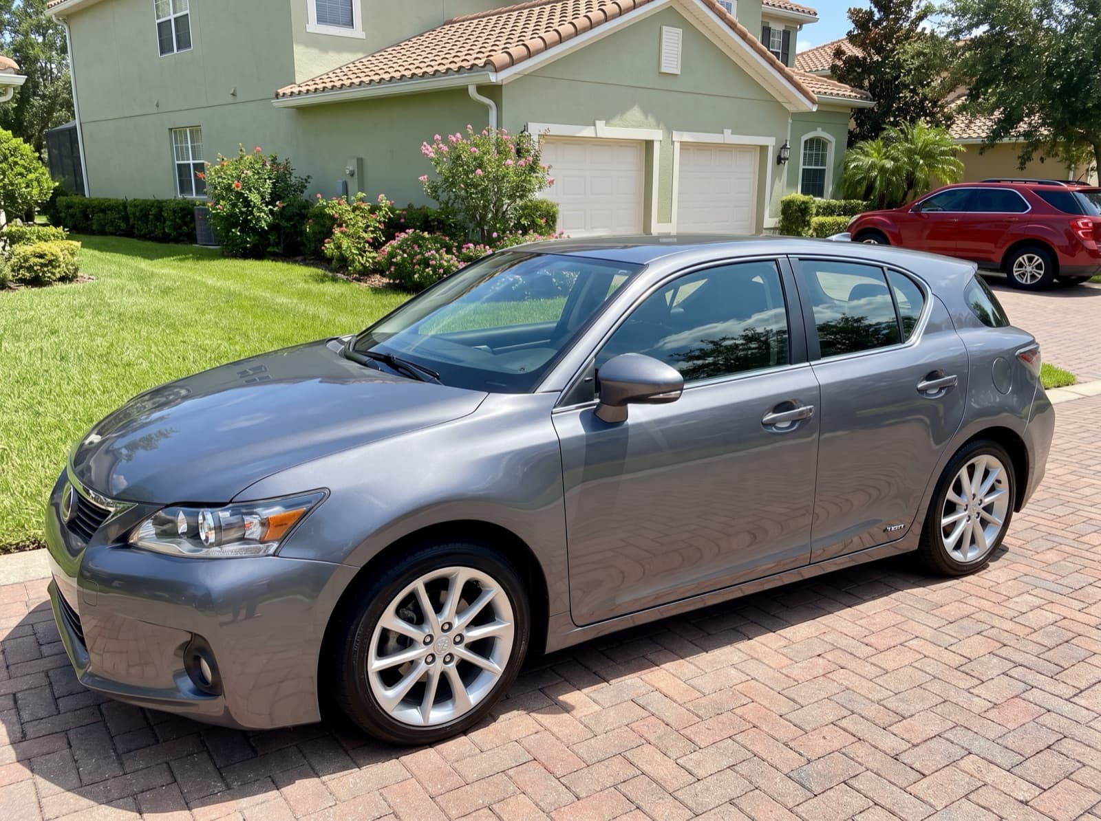 A grey hatchback on a paver driveway in Orlando, FL, after a Bang AutoGlass mobile glass job